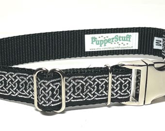 May include: Black dog collar with a silver Celtic knot design. The collar has a metal buckle and a label that says "PupperStuff". The collar is medium size.
