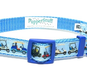 May include: A light blue dog collar with a repeating pattern of golf carts in various colors. The collar has a blue plastic buckle and a small tag with the brand name "PupperStuff". The collar is size M.