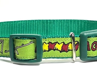 May include: Green dog collar with a lime green patterned band featuring cartoon images of a life preserver, a seesaw, and other objects. The collar has a green plastic buckle and a silver metal loop.