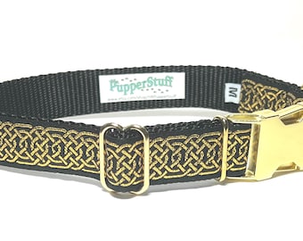 May include: Black dog collar with a gold Celtic knot design. The collar has a gold-colored buckle and hardware. The brand name "PupperStuff" is visible on a small tag. The collar is a size medium.