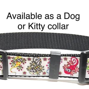 May include: A black and white dog or cat collar with a colorful gecko print. The collar has a black buckle and a silver D-ring. "Available as a Dog or Kitty collar" is written in white text on a black background.
