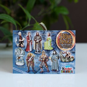 May include: A colorful card featuring characters from The Lord of the Rings. The card is blue with a white border and features images of characters from the movie, including Gandalf, Aragorn, and Frodo. The card also includes the text "The Lord of the Rings" and "The Fellowship of the Ring".