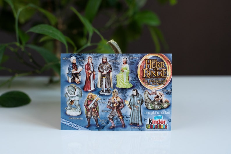 May include: A colorful card featuring characters from The Lord of the Rings. The card is blue with a white border and features images of characters from the movie, including Gandalf, Aragorn, and Frodo. The card also includes the text "The Lord of the Rings" and "The Fellowship of the Ring".