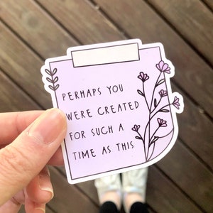May include: A purple sticker with a white border and a floral design. The sticker has the text "Perhaps you were created for such a time as this".