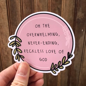 May include: Pink circle sticker with a floral design around the edge. The sticker says "Oh the overwhelming, never-ending, reckless love of God."