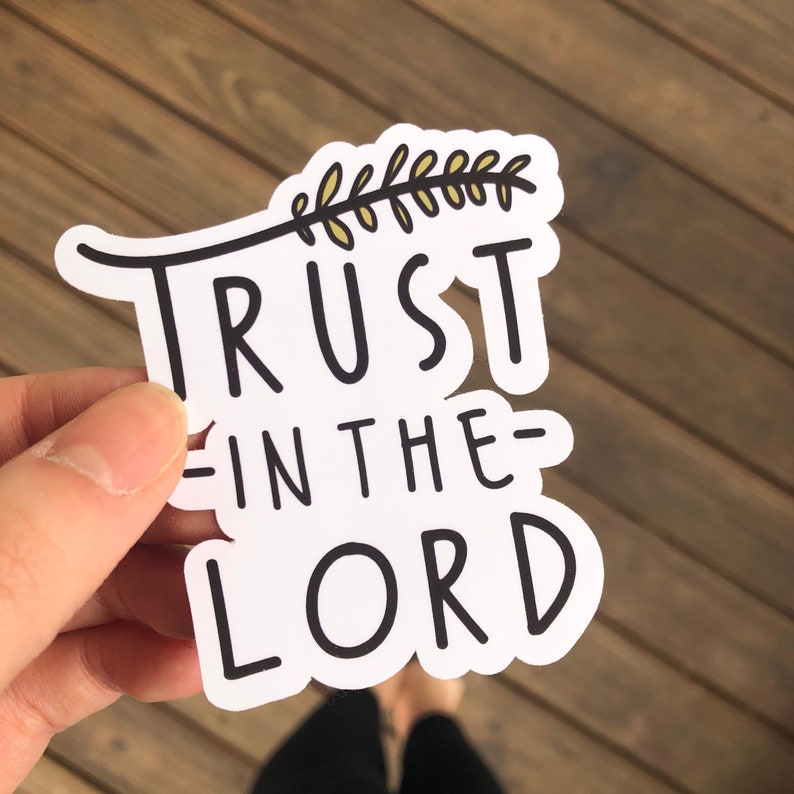 May include: White sticker with black text that reads "TRUST IN THE LORD" with a small branch with leaves above the text.
