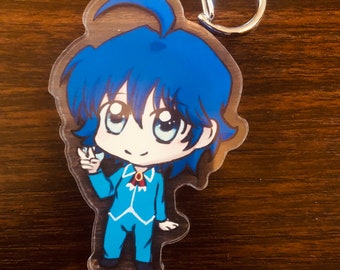 Puede incluir: Un llavero de acrílico transparente con un personaje de dibujos animados con cabello azul y un traje azul. El personaje está sonriendo y haciendo el signo de la paz. El llavero tiene un cierre plateado.