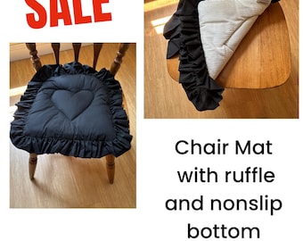May include: A black chair mat featuring a heart-shaped quilted pattern and a ruffled border. The underside is white with a textured nonslip surface. The text SALE is visible in red, and the text Chair Mat with ruffle and nonslip bottom is present.