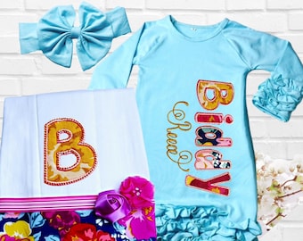 Può includere: Un set di abbigliamento per il primo compleanno di una bambina, in blu con stampa floreale. Il set comprende un vestito lungo a maniche lunghe con orlo a balze, una fascia per capelli e una coperta con una grande lettera B ricamata. Il vestito è ricamato con le parole "Birthday Queen".