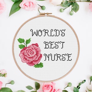 May include: A white embroidery hoop with a pink rose and the text "WORLD'S BEST NURSE" in black.