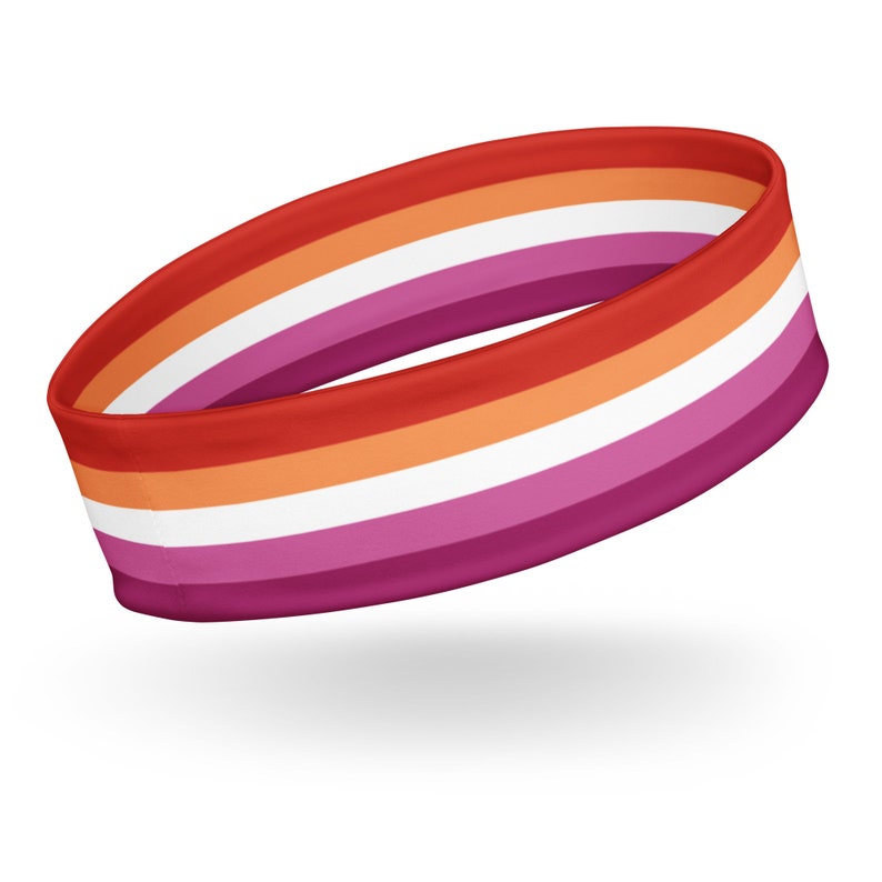 Pu&ograve; includere: Una fascia circolare con strisce orizzontali nei toni del rosso scuro, arancione, bianco e magenta. La fascia in tessuto &egrave; disposta in un anello continuo, mostrando un motivo simmetrico di bande colorate che avvolgono l'intera circonferenza.
