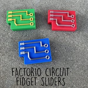 May include: Three colorful circuit board fidget sliders. One is green with gold lines, another is red with silver lines, and the last is blue with silver lines. The text "FACTORIO CIRCUIT FIDGET SLIDERS" is below the sliders.