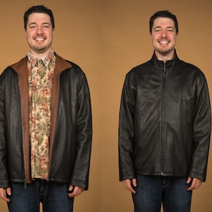 May include: A man wearing a black leather jacket with a brown collar and a floral patterned shirt underneath. He is smiling and looking at the camera.
