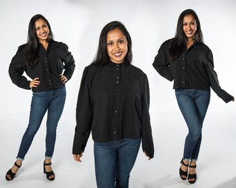 May include: A woman is wearing a black, long-sleeved button-up shirt with puffed sleeves and blue jeans. She is standing in three different poses.