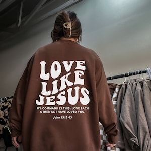 May include: Brown sweatshirt with a white graphic that says "LOVE LIKE JESUS" and the text "MY COMMAND IS THIS: LOVE EACH OTHER AS I HAVE LOVED YOU. John 15:12-13"