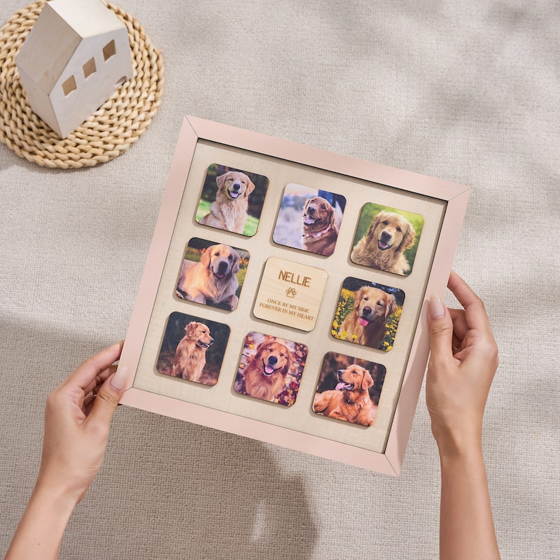 Puede incluir: Un marco de fotos cuadrado rosa claro con nueve fotos cuadradas de un Golden Retriever. Un cuadrado de madera en el centro est&aacute; grabado con el nombre "Nellie" y la frase "Once by my side forever in my heart."