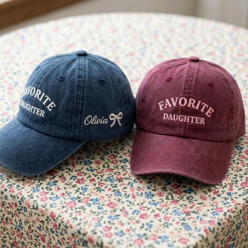 May include: A white ceramic mug with a black handle and the text "But First, Coffee" in a bold, black font. The mug is set against a blurred background, highlighting its clean design.