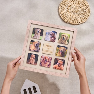 Puede incluir: Un collage de fotos de perros personalizado en un marco rosa claro. El marco contiene nueve fotos cuadradas de un golden retriever, con una placa de madera que dice "NELLIE, ONCE BY MY SIDE, FOREVER IN MY HEART".