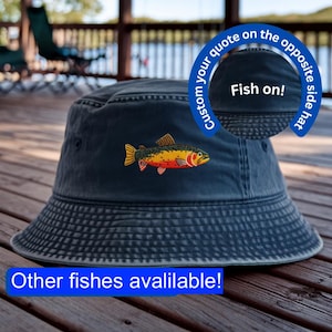 May include: A navy blue bucket hat with an embroidered fish design in yellow, orange, and red. The hat has the text "Fish on!" on the opposite side and "Other fishes avalilable!" at the bottom.