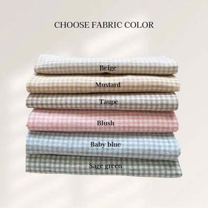 May include: A stack of fabric samples in various colors, including beige, mustard, taupe, blush, baby blue, and sage green. Each fabric has a checkered pattern. The text "CHOOSE FABRIC COLOR" is at the top.