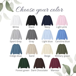 May include: A selection of crewneck sweatshirts in various colors, including white, black, navy, light pink, sport gray, gray, light blue, Carolina blue, indigo blue, sand, beige, military green, forest green, dark chocolate, and maroon. The text "Choose your color" is at the top.