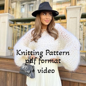Könnte beinhalten: Ein weißer Strickpullover mit lockerer, übergroßer Passform und langen Ärmeln. Der Pullover hat eine zarte, luftige Textur. Das Model trägt einen schwarzen Hut und einen weißen Plisseerock. Der Text "Knitting Pattern pdf format + video" ist über das Bild gelegt.