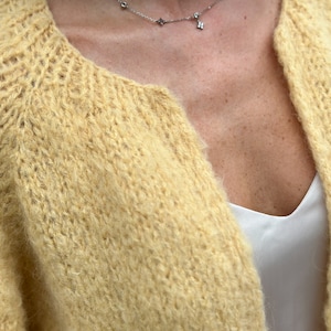 Close-up of abstract cardigan knit texture in soft yellow alpaca blend