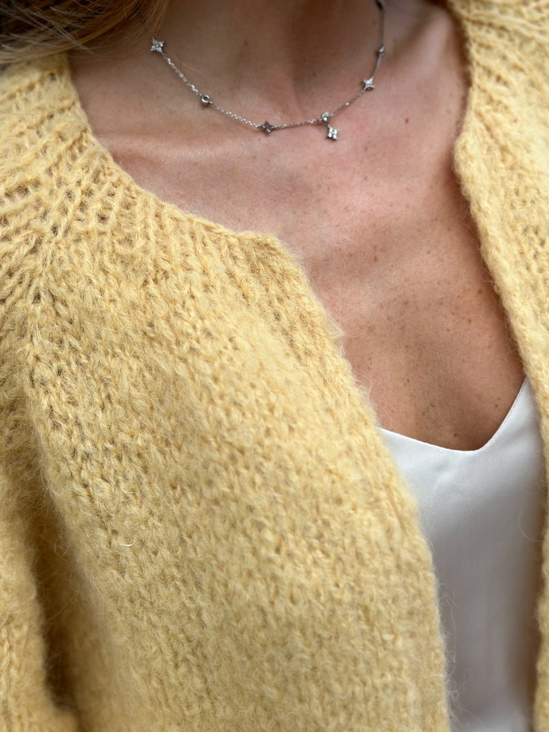 Close-up of abstract cardigan knit texture in soft yellow alpaca blend