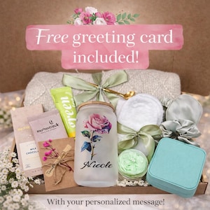 May include: A gift box filled with self-care items, including a frosted glass with a rose design and the name "Nicole", a green tube, a small jewelry box, and a small card. The box is decorated with ribbons and flowers. Text on the image reads "Free greeting card included!"