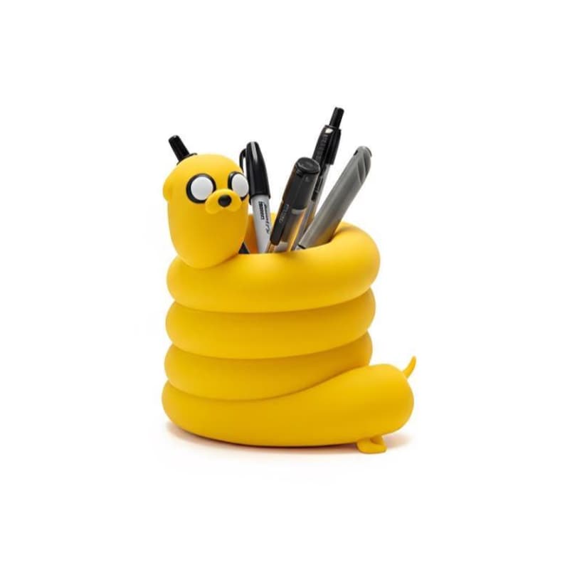 May include: A bright yellow pencil holder shaped like a coiled cartoon dog with a rounded head, large white eyes, and a black nose. The cylindrical body features a hollow center containing several black and grey pens and markers for storage.