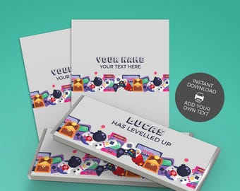 May include: A set of rectangular candy bar wrappers featuring a light gray background and a colorful bottom border of video game icons including controllers, treasure chests, and bombs. The text reads YOUR NAME YOUR TEXT HERE and LUCAS HAS LEVELLED UP.
