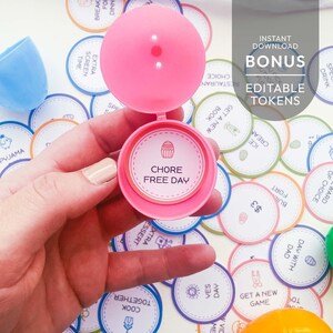 May include: A pink plastic egg container holding a circular paper token with a cupcake icon and the text CHORE FREE DAY. The background features numerous scattered circular tokens with various icons and text, plus the overlay text BONUS EDITABLE TOKENS.