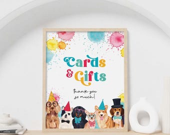May include: A framed sign featuring the text Cards & Gifts and thank you so much, decorated with colorful watercolor paint splatters and an illustration of six dogs wearing party hats, bow ties, and glasses in various colors.