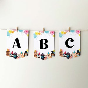 May include: A colorful banner with the letters A, B, and C. Each letter is surrounded by a watercolor design of colorful splatters. The banner features a row of cartoon dogs wearing party hats.