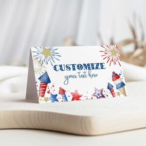 May include: A folded white card featuring watercolor illustrations of red, white, and blue fireworks, stars, and a rocket-shaped ice cream cone. The text CUSTOMIZE your text here is printed in blue in the center of the card.