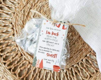 May include: A clear plastic treat bag tied with twine, featuring a rectangular tag that reads: Dear Beau and Evie, I'm Back FROM THE NORTH POLE AND I BROUGHT YOU A TREAT! I'll be reporting to Santa each day so remember to be extra SWEET! Love your Elf, Buddy.