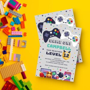 May include: Two rectangular party invitations with a light gray background featuring colorful confetti, black and white game controllers, and the text GAME ON! CAMPBELL HAS REACHED LEVEL 12, including event details and a yellow shield icon.