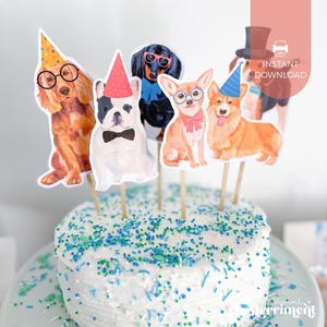 May include: A white frosted cake with blue and green sprinkles, topped with dog-themed party decorations. The decorations include cutouts of dogs wearing party hats, glasses, and bow ties. The cake is on a white plate.