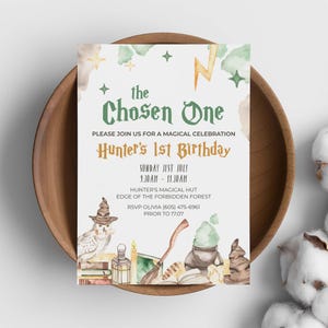 Puede incluir: Una invitación caprichosa con el texto "the Chosen One" y "Hunter's 1st Birthday". El diseño presenta ilustraciones en acuarela de un búho, una escoba y una poción, con un rayo y estrellas. La invitación está en un cuenco de madera.