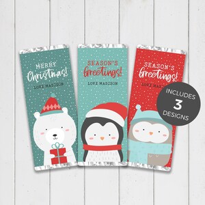 Könnte beinhalten: Drei weihnachtliche Schokoriegelverpackungen. Eine Verpackung zeigt einen Eisbären und den Text "Merry Christmas!". Die anderen beiden haben Pinguin- und Eulen-Grafiken mit "Season's Greetings!". Die Verpackungen sind türkis und rot.