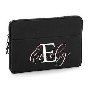 Könnte beinhalten: Schwarze Laptoptasche mit einem weißen Reißverschluss und einem weißen personalisierten Design, das "Emily" mit einem großen weißen "E" in der Mitte sagt.