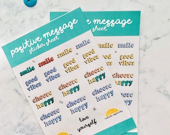 May include: Two turquoise blue sticker sheets with white text that reads "positive message sticker sheet" and "message sheet". The sticker sheets feature colorful stickers with positive messages such as "smile", "good vibes", "choose happy", and "love yourself".