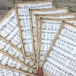 Pu&ograve; includere: Una collezione di spartiti musicali vintage con canti natalizi, tra cui "Stille Nacht", "Gioia al mondo", "Dio vi benedica", "Il primo Natale", "I tre re magi", e "Ecco l'angelo del Signore". Le pagine sono invecchiate e hanno un aspetto usurato.