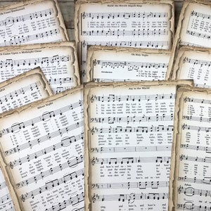 Pu&ograve; includere: Una collezione di spartiti musicali di canti natalizi vintage con titoli come "Oh Come, Oh Come Emmanuel", "Hark! The Herald Angels Sing", "It Came Upon a Midnight Clear", "Oh Holy Night", "Joy to the World", "We Three Kings" e "God Rest You Merry, Gentlemen". La musica &egrave; stampata su carta invecchiata con un aspetto usurato e sbiadito.