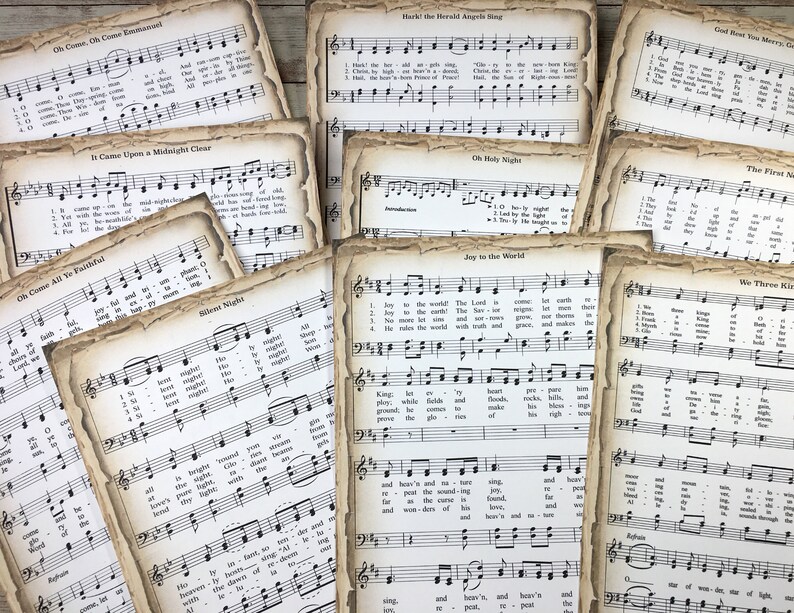 Pu&ograve; includere: Una collezione di spartiti musicali di canti natalizi vintage con titoli come "Oh Come, Oh Come Emmanuel", "Hark! The Herald Angels Sing", "It Came Upon a Midnight Clear", "Oh Holy Night", "Joy to the World", "We Three Kings" e "God Rest You Merry, Gentlemen". La musica &egrave; stampata su carta invecchiata con un aspetto usurato e sbiadito.