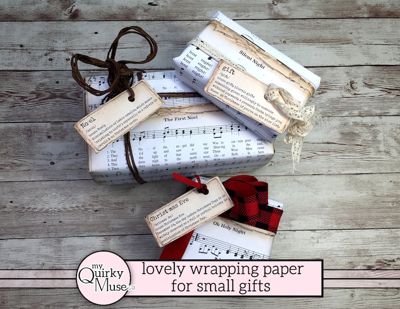 Pu&ograve; includere: Tre piccole scatole regalo avvolte in carta musicale vintage con spago marrone ed etichette. Le etichette riportano le parole "Noel", "The First Noel", "Silent Night", "Christmas Eve" e "Oh Holy Night". Le scatole sono appoggiate su una superficie in legno chiaro.