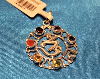 May include: Silver pendant with a seven-chakra Om symbol, featuring colorful gemstones in a circular design. The pendant is labeled "Seven Chakras".