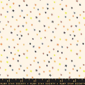 May include: A white fabric with a repeating pattern of small, hand-drawn stars in shades of yellow, orange, brown, and blue.