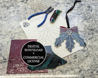 Op de afbeelding: Een glas-in-lood hulstbladornament met een rode en paarse strik, blauwe bladeren en een zwart lint. Ook afgebeeld zijn glasstukken, een patroon en gereedschap. Digitale download met commerciële licentie.