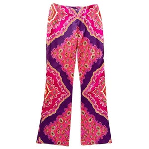 May include: Full-length trousers featuring a vibrant, symmetrical kaleidoscope pattern in shades of deep purple, bright magenta, and soft pink. The design consists of repeating diamond-shaped motifs with intricate floral-like details throughout.
